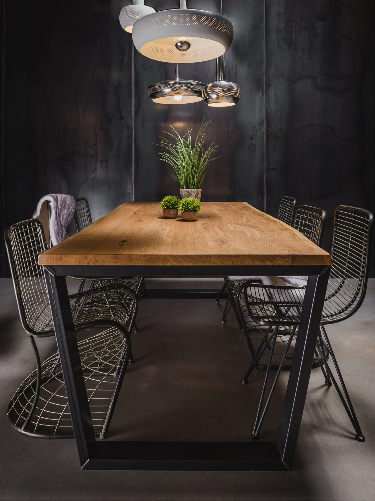 wildeiche esstisch mit stahlgestell frontalansicht im loft mit stuehlen und massiver holzplatte