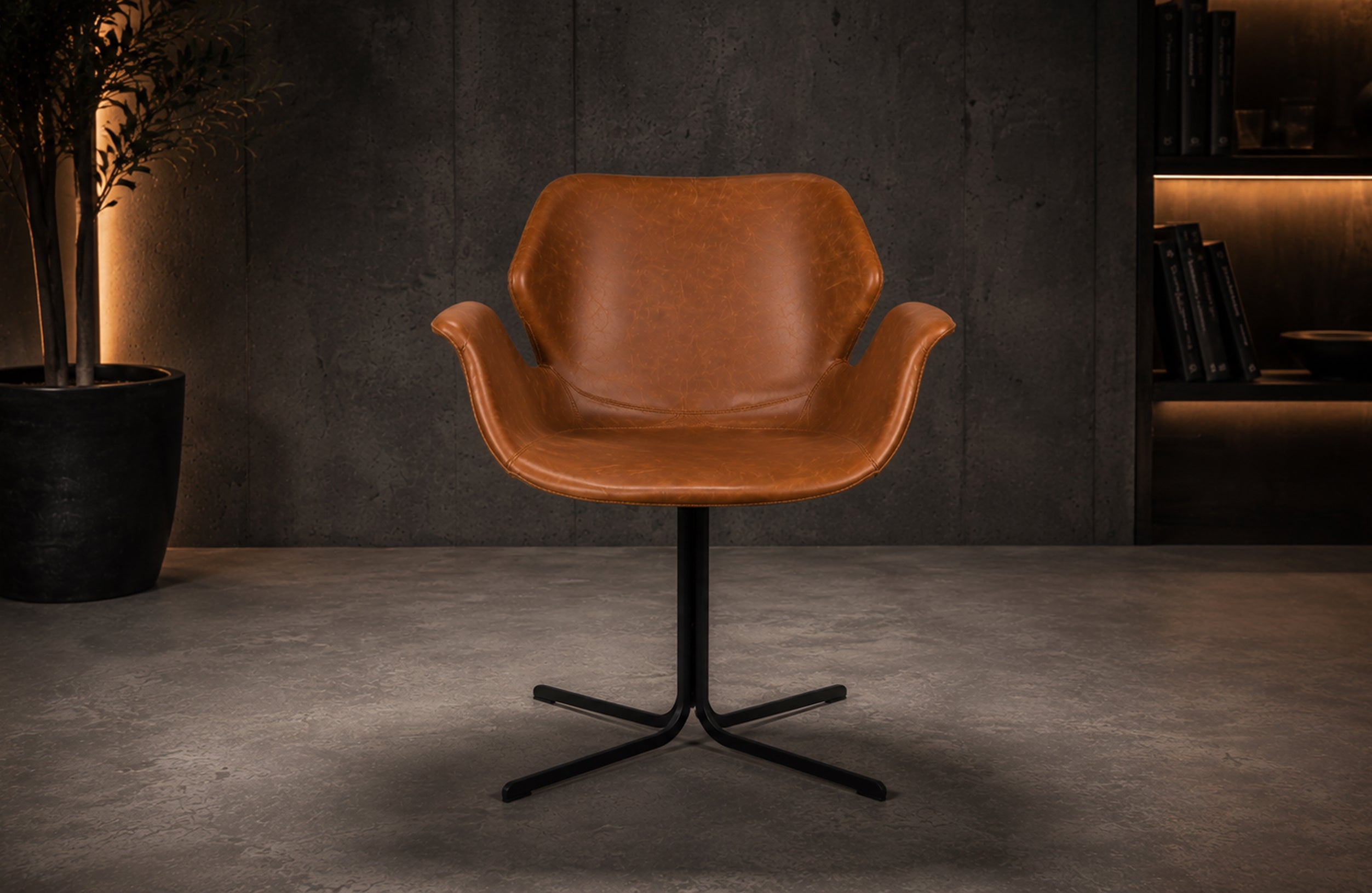 Design Stuhl Falke im modernen Ambiente mit cognacbraunem Leder, Armlehnen und schwarzem Stahlgestell im Lagom Stil