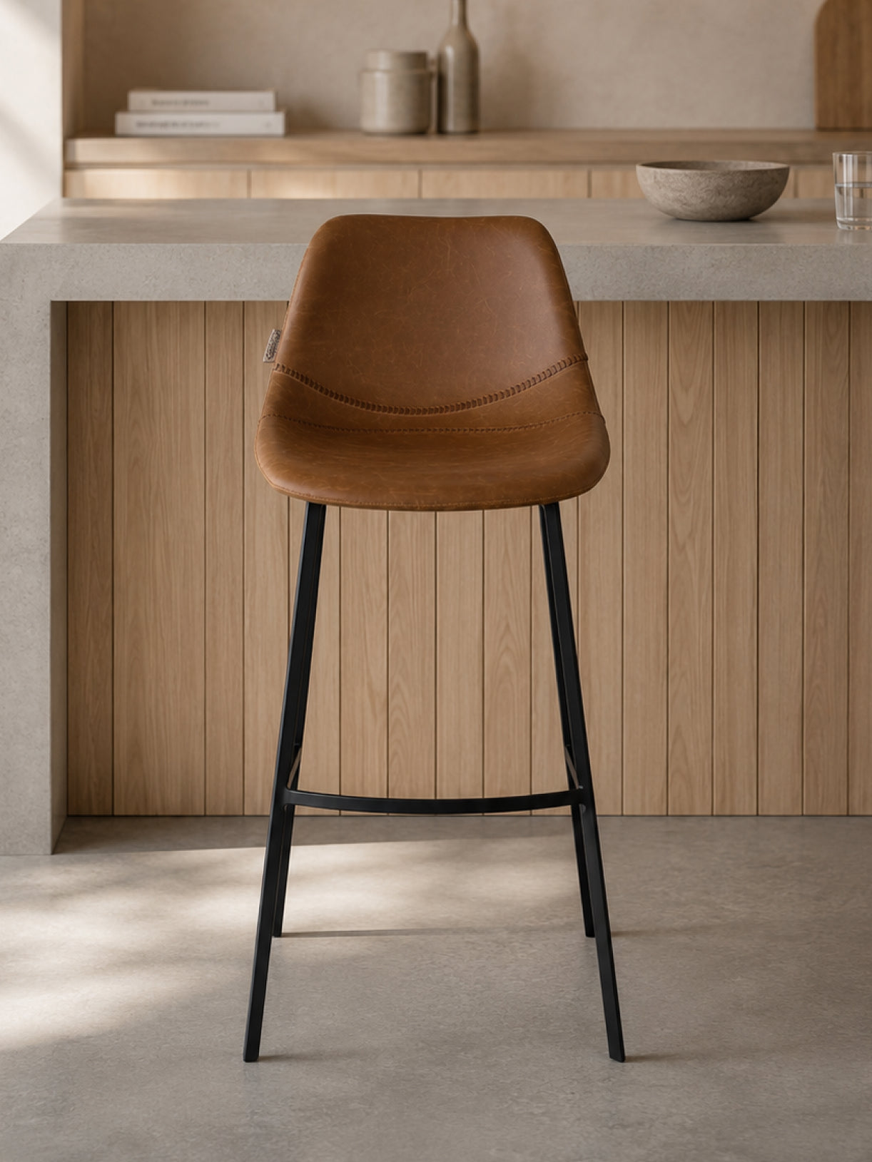 Barhocker Ross in Frontalansicht vor einer hellen Hausbar mit Holz und Betonoptik, modernes Vintage-Design