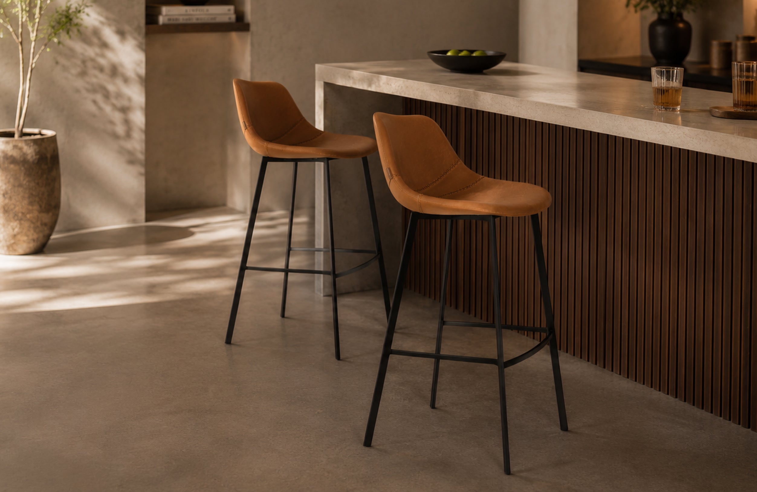 Barhocker Ross in mehrfacher Ausführung an einer hellen, minimalistischen Hausbar mit Holzfront und Betonoptik