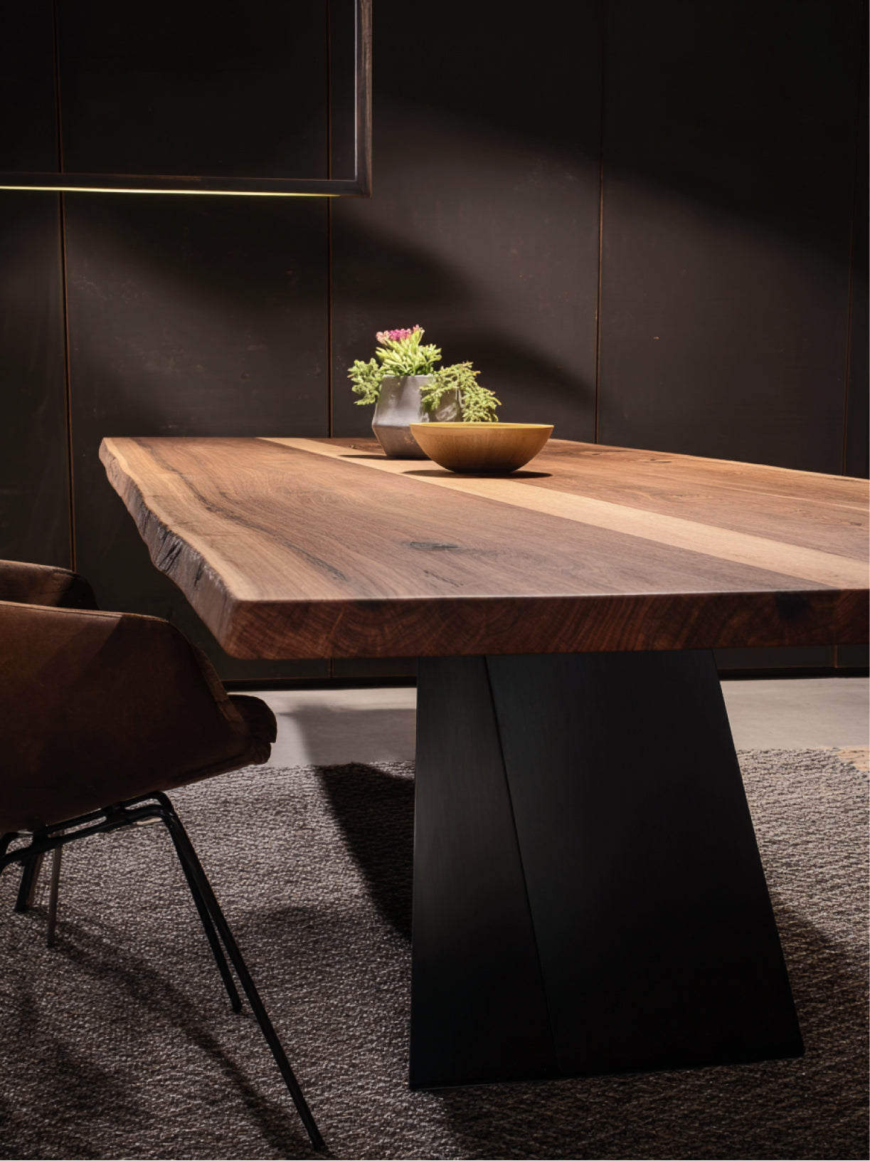 Massiver Nussbaum-Esstisch von Möbelloft mit schwarzem Stahl-Designfuß und Baumkante im modernen Ambiente