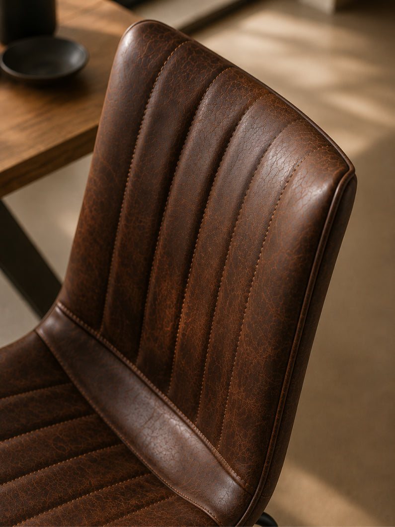Detailbild vom Stuhl Diego mit vertikal gesteppter Rückenlehne und charaktervoller Oberfläche in brauner Vintage-Optik