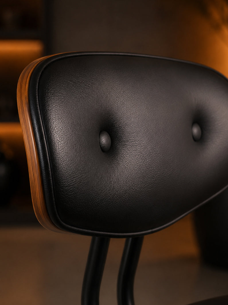 Detailaufnahme vom Design Stuhl Puma mit schwarzer Polsterlehne, charakteristischen Knopfdetails und walnussfurnierter Holzschale