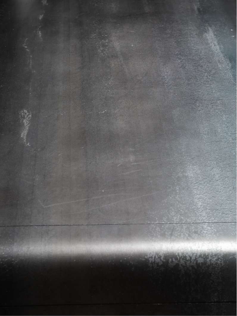 Detailbild der puren Stahlplatte vom Purer Stahl Tisch mit sichtbarer Oberfläche und handwerklichem Finish